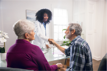 Photo of a hypothetical patient in a plaid shirt reviewing medical records with a healthcare provider with a loved one