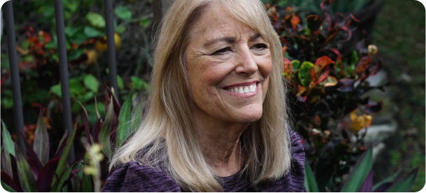 Teri, a REBLOZYL patient, smiling in a garden