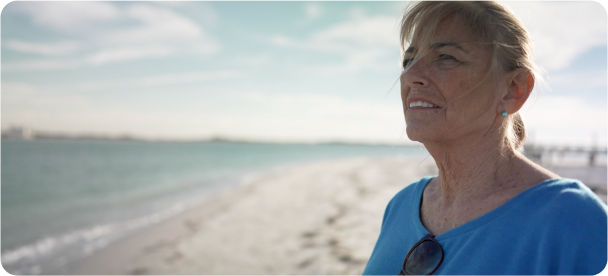 Teri, a Reblozyl patient, standing by the beach